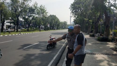 Polisi mengarahkan pejalan kaki menghindari pedestrian Jalan Medan Merdeka Utara, Jakarta Pusat. Medcom.id/Ilham Pratama Putra.