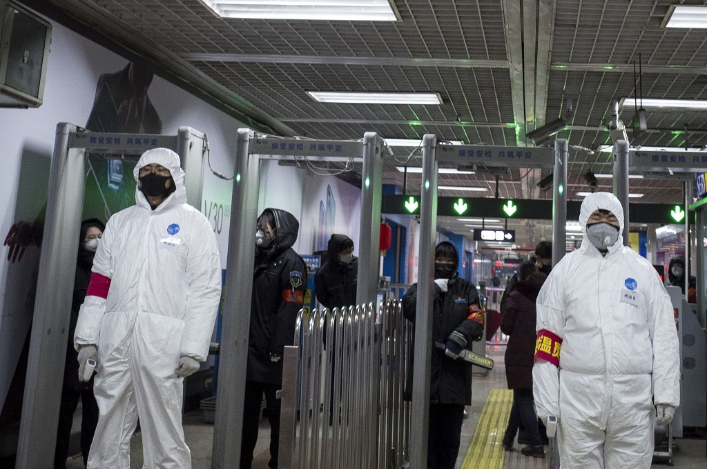 Petugas keamanan dengan pakaian pelindung bersiaga di sebuah stasiun kereta bawah tanah di Beijing, Tiongkok, 26 Januari 2020. (Foto: AFP/NOEL CELIS)