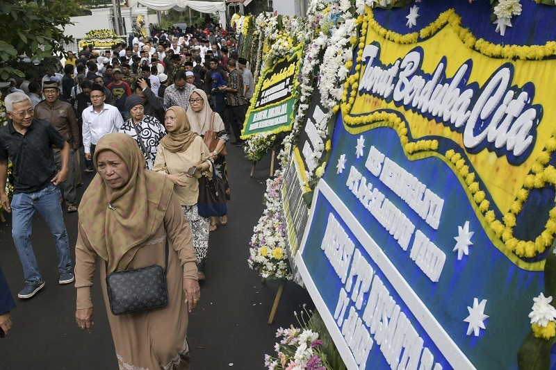 Sejumlah pelayat melintas di depan karangan bunga ucapan belasungkawa atas wafatnya KH Salahuddin Wahid di Mampang Prapatan, Jaksel. Foto: ANT/GALIH PRADIPTA
