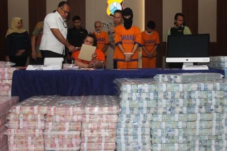 Polisi menghadirkan tersangka dan barang bukti uang saat ungkap kasus investasi ilegal di Polda Jawa Timur, Surabaya, Jawa Timur. (Foto: ANTARA/Didik Suhartono)