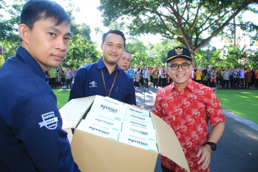 Bupati Banyuwangi, Abdullah Azwar Anas, saat menyerahkan bantuan ribuan masker kepada Kepala Kantor Pos Banyuwangi Vicky Vidianto, untuk dikirim ke warga Banyuwangi di Hongkong, Kamis, 13 Februari 2020. Dokumentasi/ Pemkab Banyuwangi