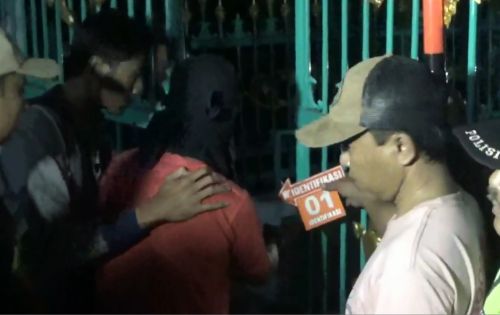 Terduga pelaku pembunuhan menggunakan penutup kepala saat  pra rekonstruksi di Desa Ngunut, Kecamatan Ngunut, Kabupaten Tulungagung, Jawa Timur. (foto/dw)