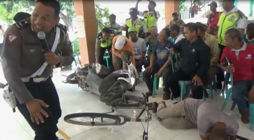 Petugas Satlantas Polres Bojonegoro melakukan simulasi penyelamatan korban kecelakaan lalu lintas di depan warga Desa Pasinan