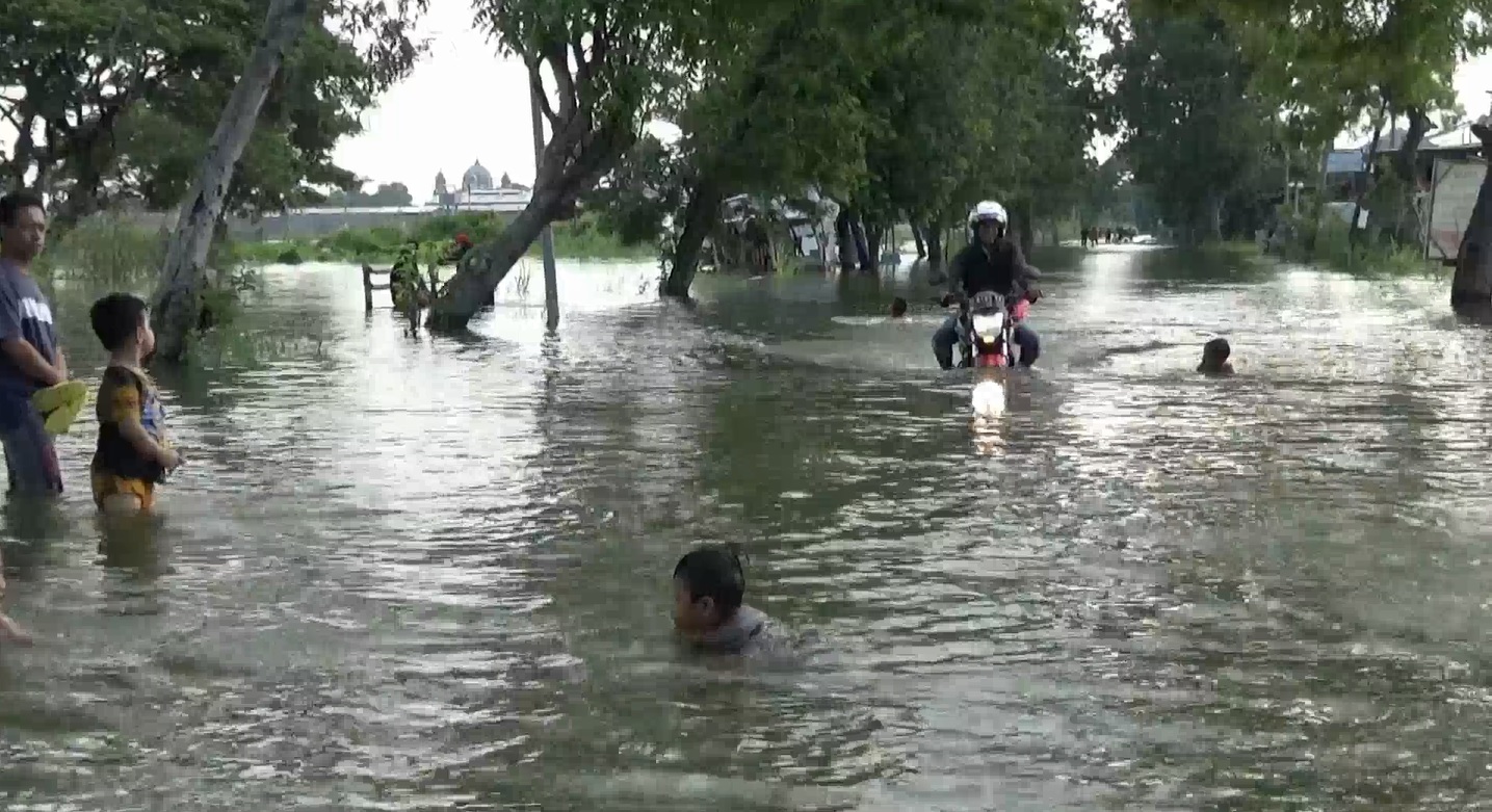 Pengendara motor memilih menerjang banjir daripada harus memutar arah