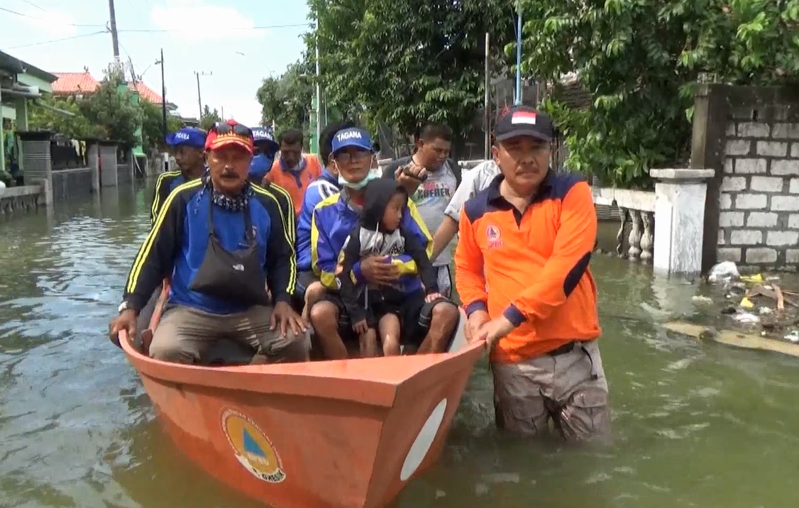 Petugas memantau kondisi warga Desa Dungus, Gresik dengan menggunakan perahu. (foto/metrotv)