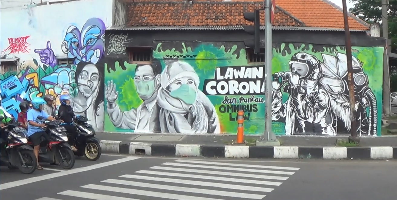 Mural berisi ajakan untuk melawan Covid-19 di Jalan Wonokromo menjadi perhatian pengendara yang melintas  