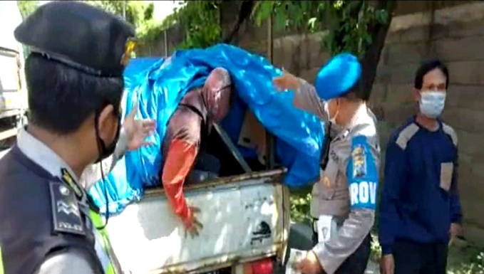 Polisi mengeluarkan satu persatu para pemudik yang sembunyi di balik terpal. (foto/metrotv)