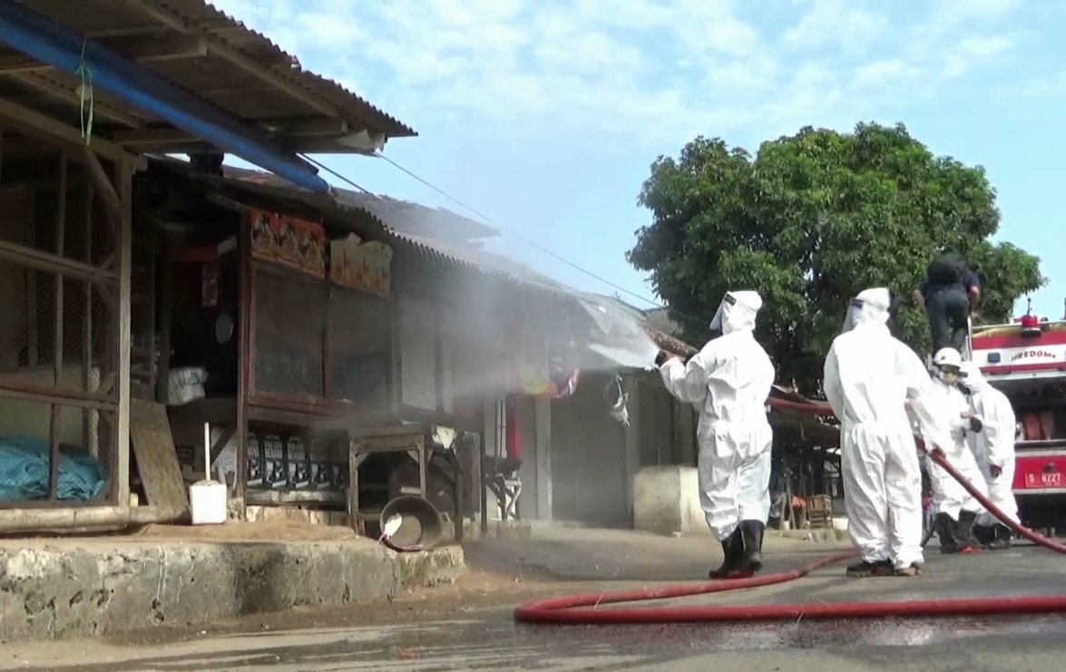 Lapak para pedagang Pasar Bongkaran Tuban disemprot disinfektan. (foto/metrotv)