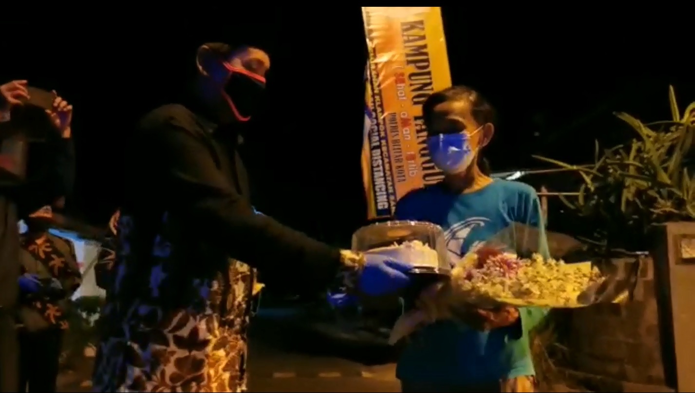 Seorang pasien yang dinyatakan sembuh covid-19 disambut dengan pemberian bunga dan kue untuk menepis anggapan negatif warga setempat (foto/metrotv)