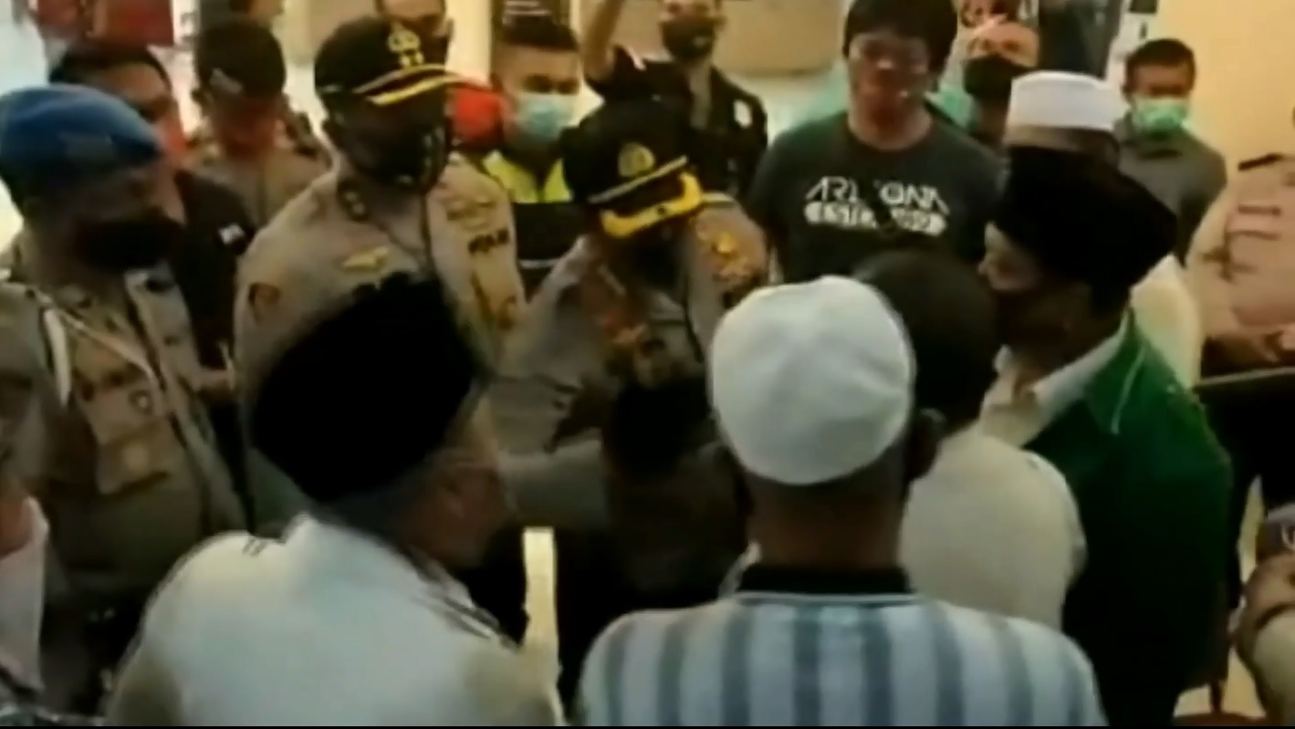 Petugas Polres Sidoarjo mencoba menghalangi dan memberikan pengertian terhadap keluarga pasien PDP yang meninggal untuk tak melakukan penjemputan paksa (foto/metrotv)