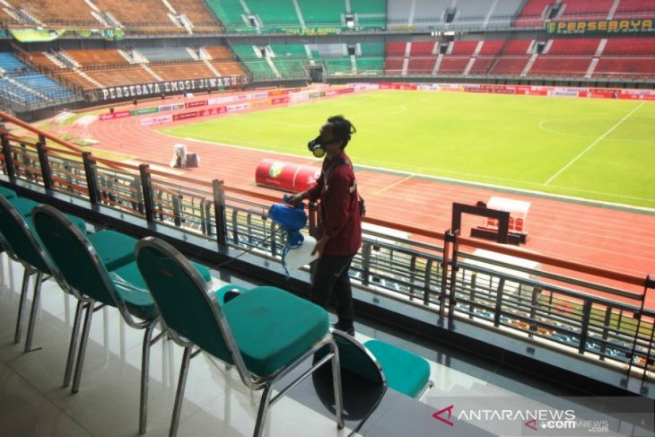 Petugas menyemprotkan larutan disinfektan di Stadion Gelora Bung Tomo, Surabaya, Jawa Timur, Jumat (13/3/2020) untuk mengantisipasi penyebaran covid-19. (Foto : ANTARA Jatim/Didik Suhartono)