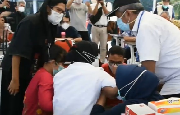 Wali Kota Surabaya Tri Rismaharini  (baju putih) coba dibangunkan usai menangis sambil bersimpuh di kaki dokter. (foto/metrotv) 