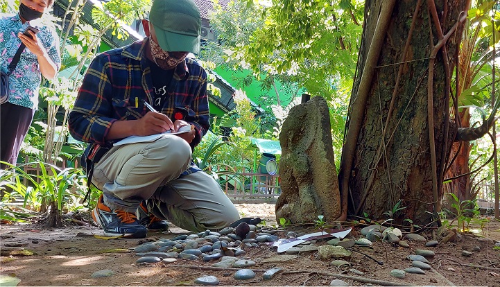 Petugas BPCB  Trowulan mengindentifikasi penempuan arca dewa budha klasik di halaman SMPN 1 Tulunagung (foto/Metrotv)