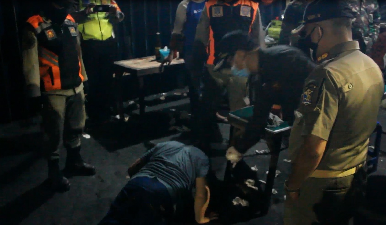 Seorang pedangan di wilayah Tambaksari dihukum push up lantaran tak menghiraukan penjelasan petugas terkait pemberlakuan jam malam di Surabaya. (foto/metrotv)