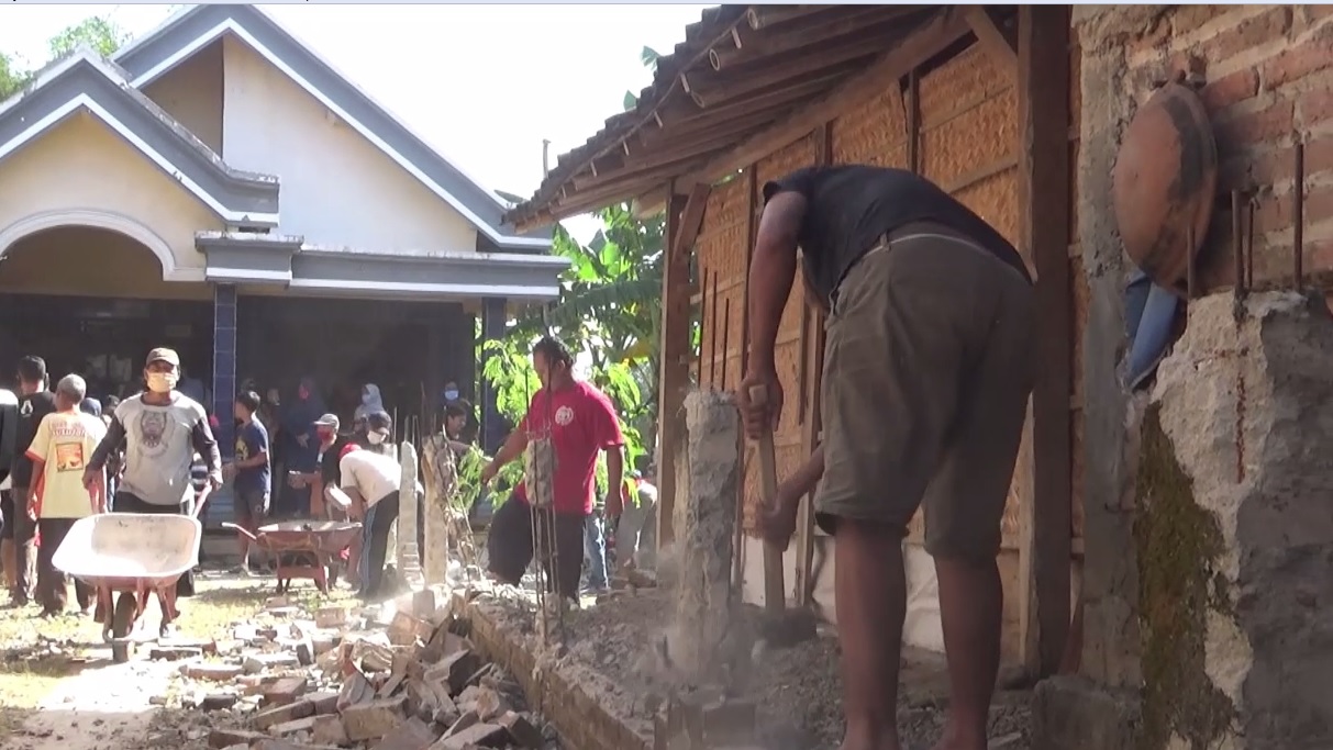 Warga membongkar tembok yang menghalangi salah satu rumah di Desa Gandukepuh,  Kecamatan Sukorejo, Ponorogo. (foto/metrotv) 