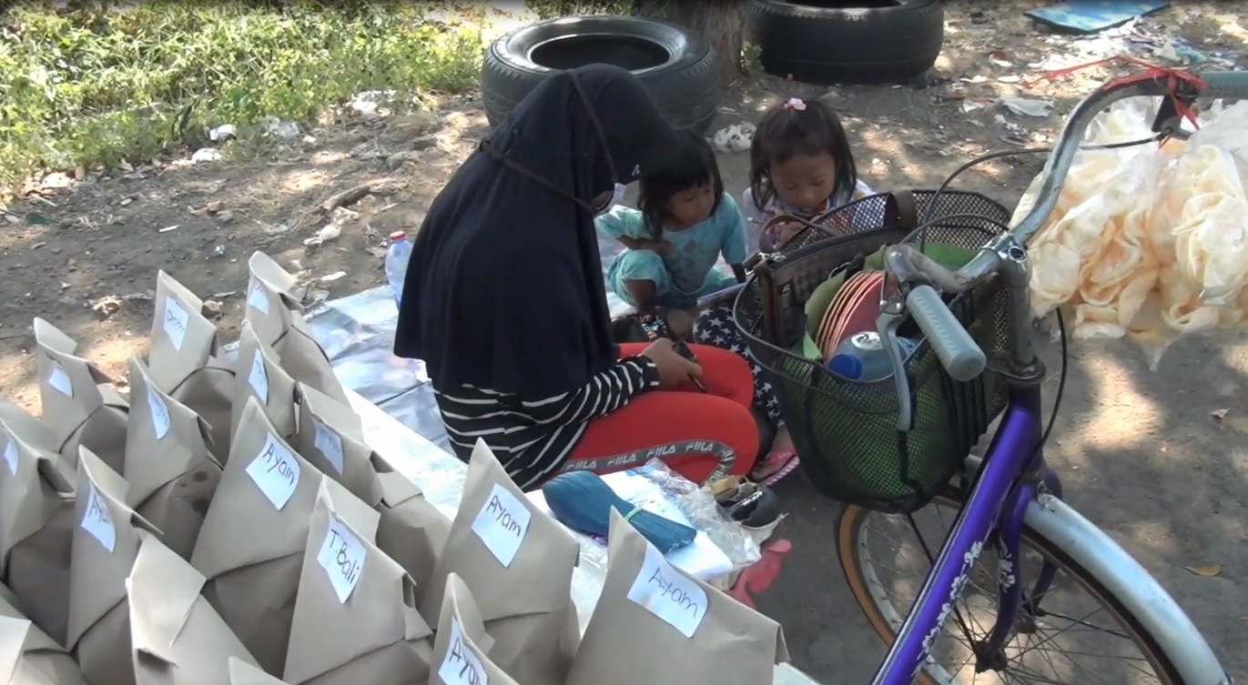 Sovi Dwi Aprilia bersama ibu dan adiknya belajar sambil berjualan nasi bungkus Perumahan Delta Sari Sidoarjo. (foto/metrotv)