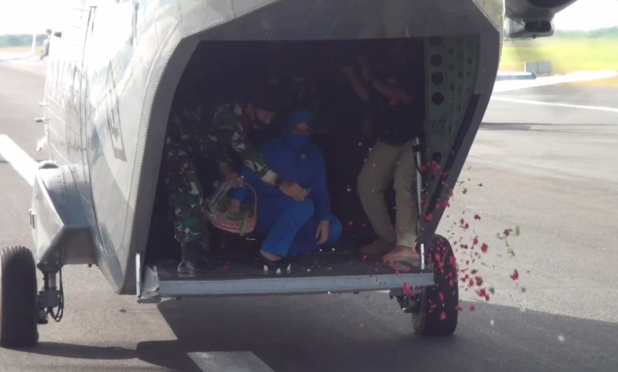 Prajurit TNI AL melakukan tabur bunga dari atas pesawat di sepanjang run way Bandara Juanda. (foto/metrotv)