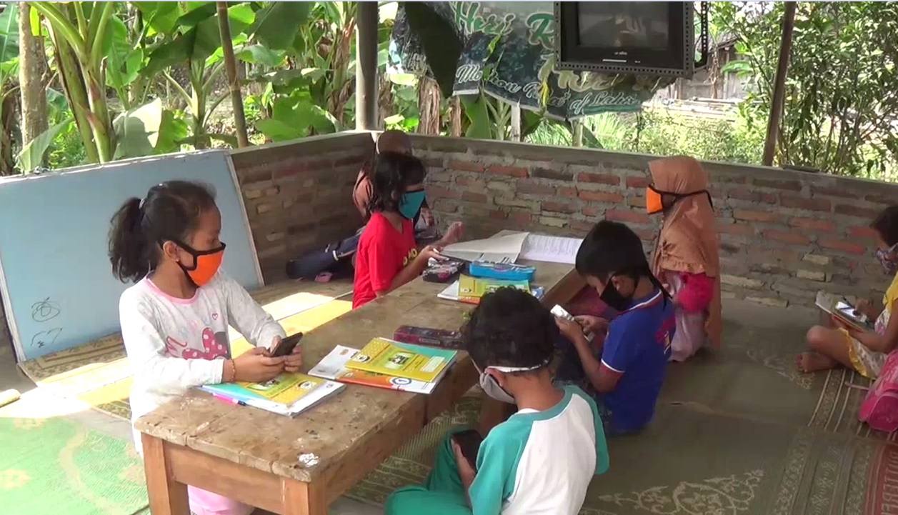 Sejumlah siswa di lereng Gunung Lawu memanfaatkan wifi gratis yang ada di Poskamling untuk belajar daring. (foto/metrotv)