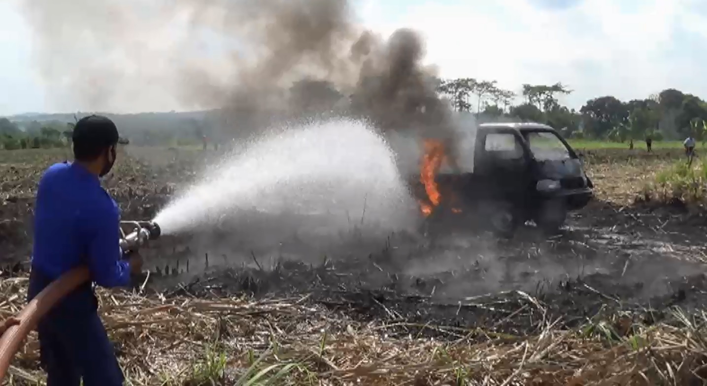 Tim pemadam kebakaran saat memadam api di pikap yang terbakar di tengah lahan tebu (Foto / Metro TV)