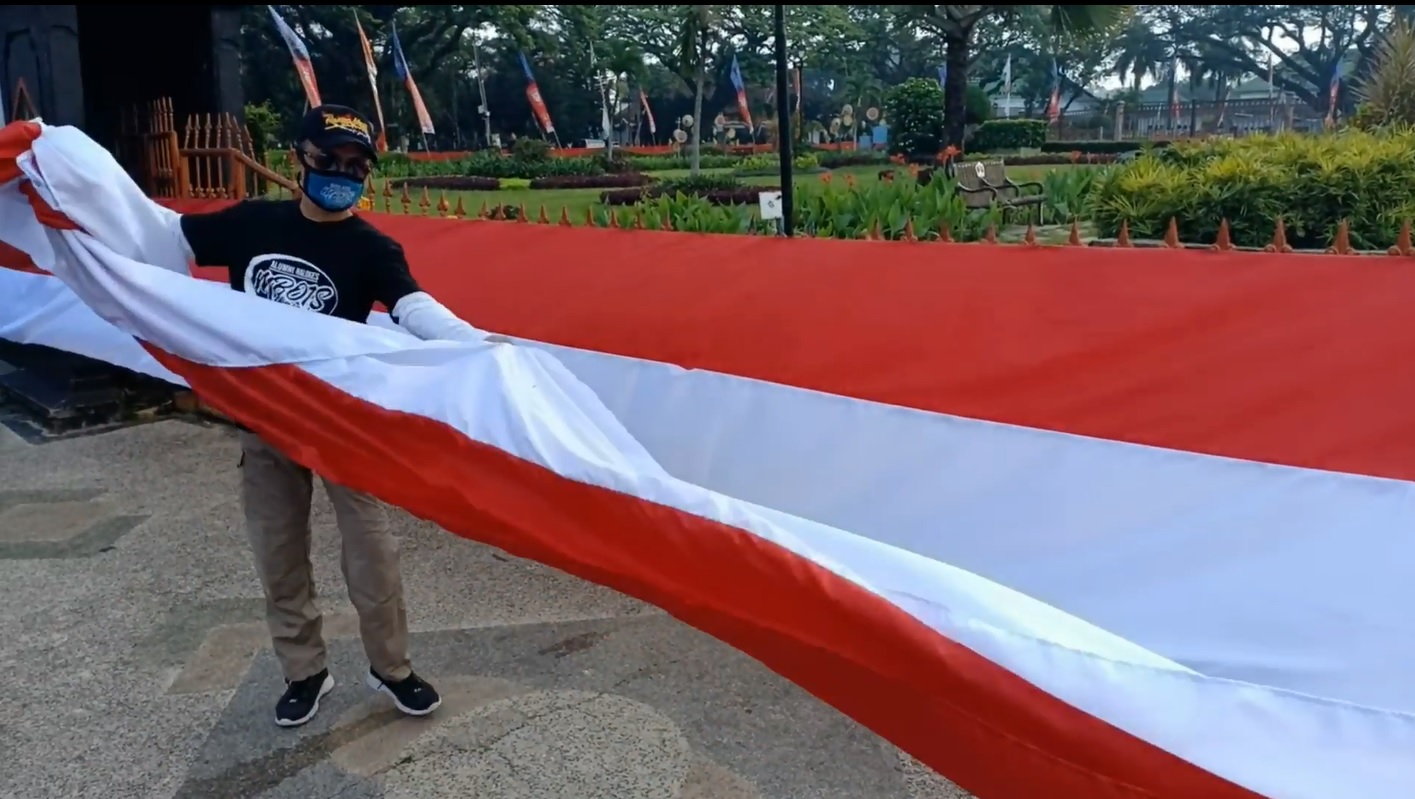 Prosesi pemasangan bendera sepanjang 366 meter di Alun-alun Tugu Malang. (foto/metrotv) 