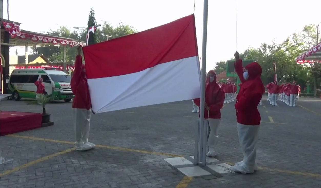 Tenaga kesehatan di Rumah Sakit Sidoarjo mengelar upacara bendera dengan memakai APD lengkap berwarna merah putih. (foto/metrotv)