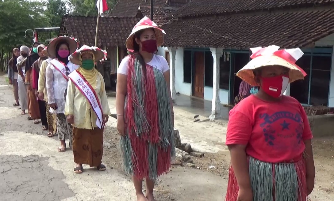 Warga Desa Krajan mengelar upacara di jalan dengan berbagai kostum baju daerah. (foto/metrotv)