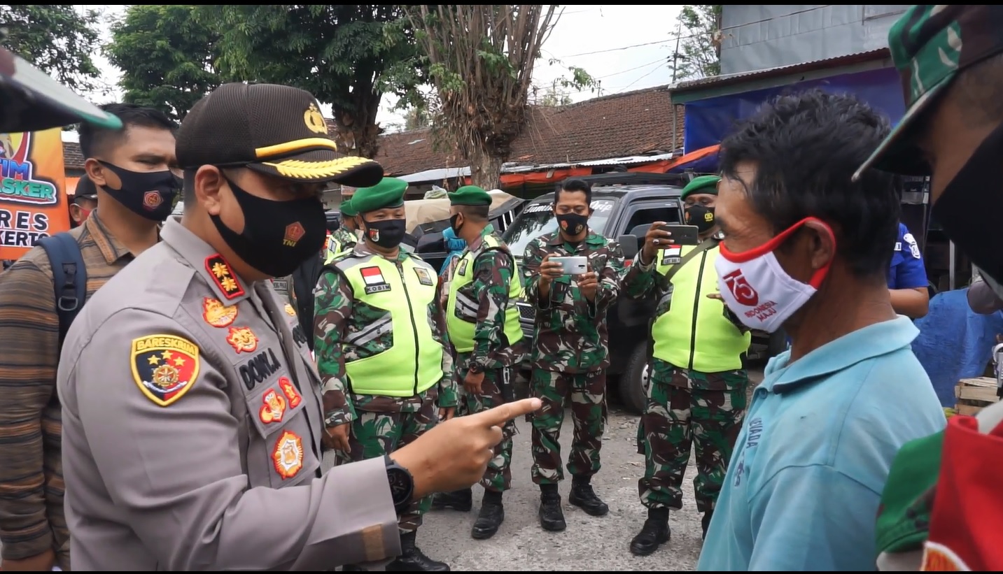 Kapolres Mojokerto, AKBP Dony Alexander saat memarahi sejumlah pedagang yang enggan menggenakan masker di pasar (Foto / Metro TV)