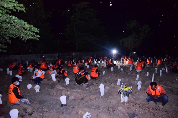 Puluhan pelanggar protokol kesehatan di Sidoarjo sedang dihukum berdoa di kuburan korban covid-19 tengah malam (Foto / Metro TV)