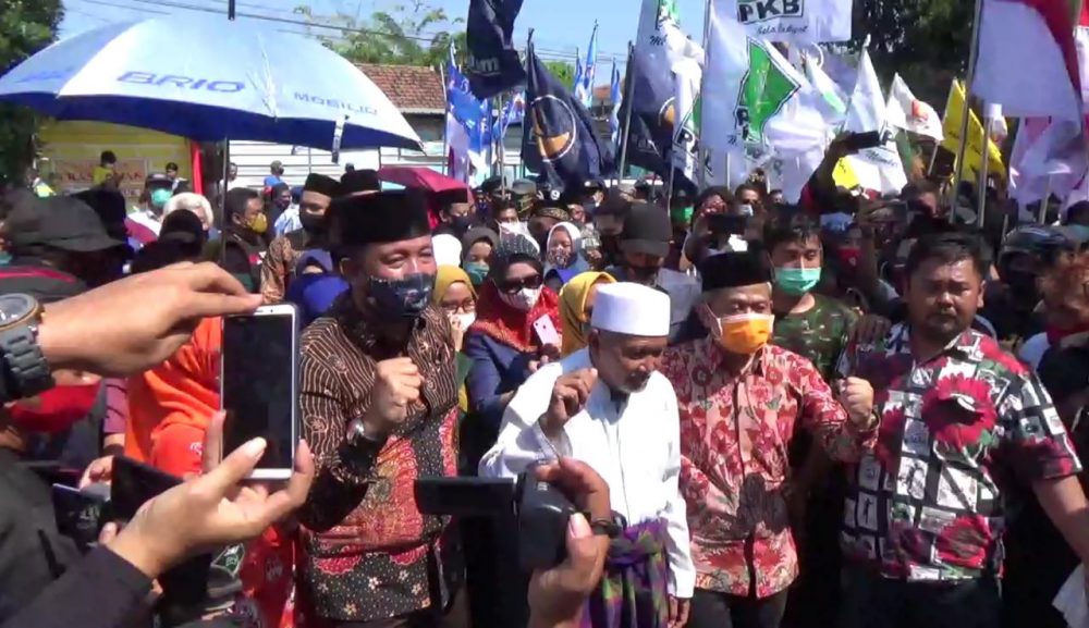 Ribuan massa mengantar pasangan bakal calon bupati dan wakil bupati Ponorogo, Ipong Muchlissoni dan Bambang Tri Wahono mendaftar ke kantor KPUD