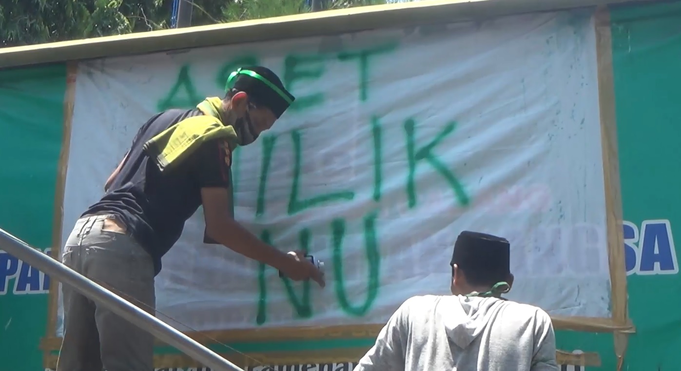 Pendemo menutup papan nama DPC PKB Kediri lantaran dianggap aset milik NU (Foto / Metro TV)