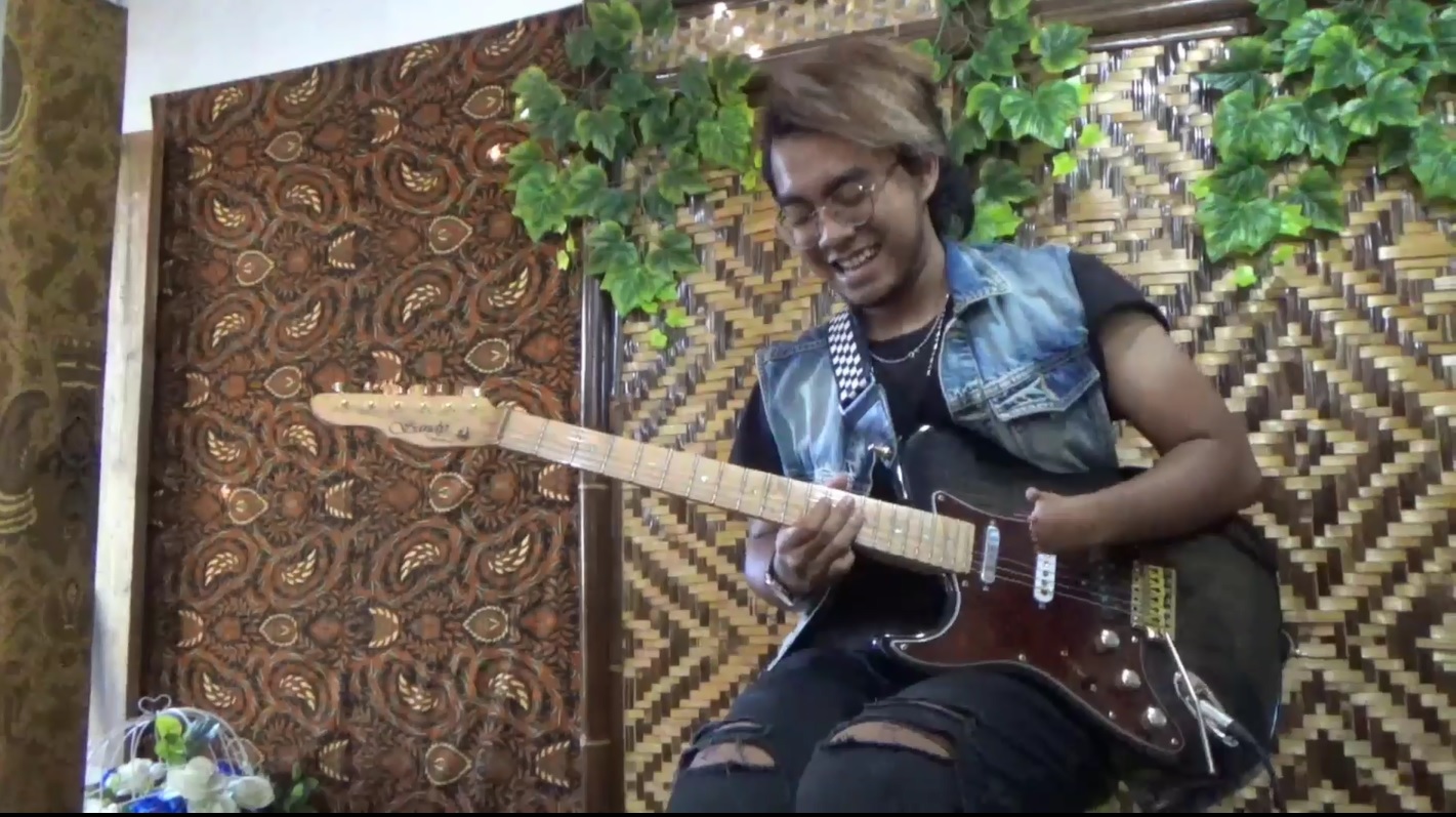  Sandy Sri Yuwana tetap piawai memainkan gitarnya meski jari-jari tangannya tak tumbuh normal (Foto / Metro TV)