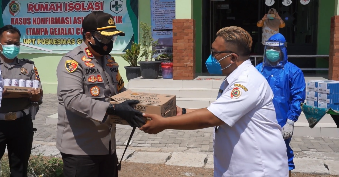 Polisi memberikan bantuan vitamin ke rumah isolasi khusus OTG di Puskesmas Mojokerto (Foto / Metro TV)
