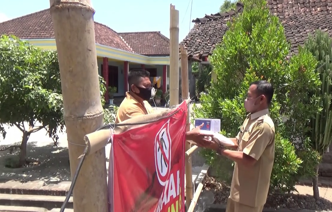 Perangkat desa menyerahkan bantuan sembako dari BPBD Ponorogo. (metrotv)