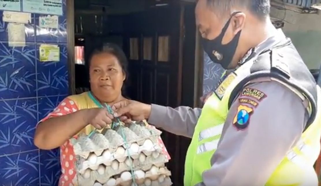 Aipda Purnomo membagikan telur kepada warga korban PHK. (metrotv)