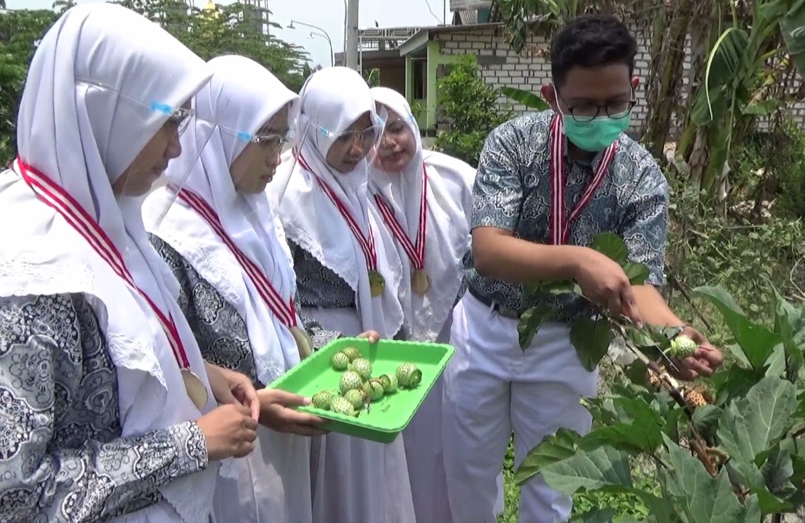 Lima siswa MAN I Gresik saat memetik buah kecubung. (metrotv)