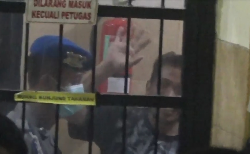 Yunus Wahyudi melambaikan tangan saat dijebloskan dalam penjara Mapolres Banyuwangi. (metrotv)