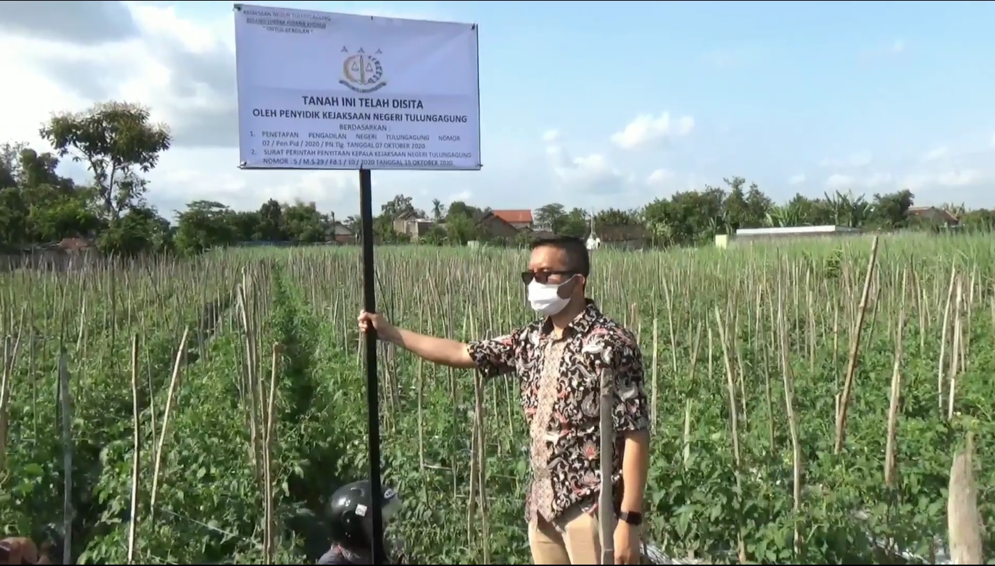 Kasi Intel Kejari Tulungagung, Agung Tri Radityo saat melakukan penyitaan salah satu tanah milik tersangka Djoko Hariyanto (Foto / Metro TV)