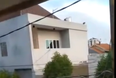 Tampak pencuri berkaos putih berlari di atas atap rumah menghindari kepungan warga. (metrotv)