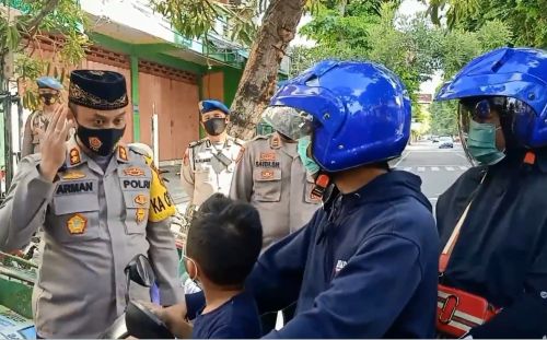 Kapolres Pasuruan Kota,  AKPB  Arman memberikan masker dan helm gratis kepada pelanggar lalu lintas yang terjaring Operasi Zebra. (metrotv)