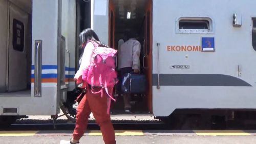 Seorang penumpang hendak masuk ke gerbong kereta api di stasiun Gubeng Surabaya (Foto / Metro TV)