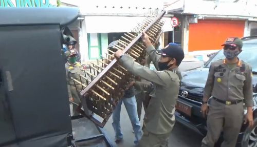 Petugas gabungan mengangkut alat musik para pengamen jalanan. (metrotv)