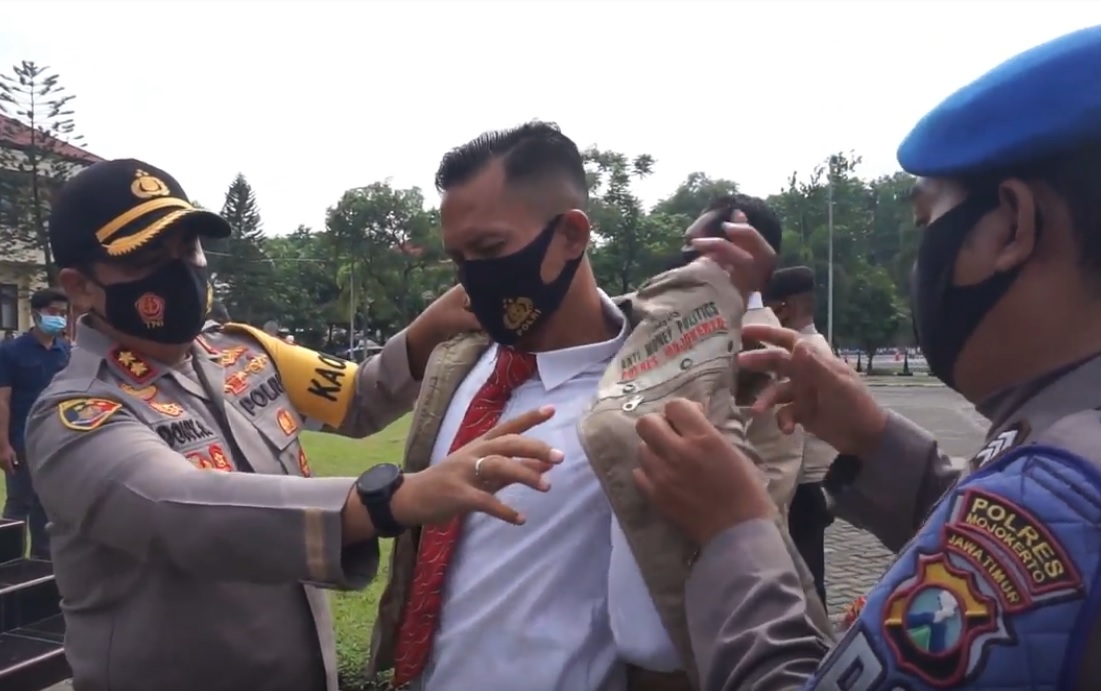 Kapolres Mojokerto AKBP Dony Alexander memakaikan rompi kepada anggota Tim Anti Money Politic (metrotv)