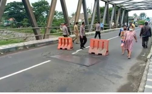 Lubang di tengah jembatan membahayakan kendaraan. (ist)