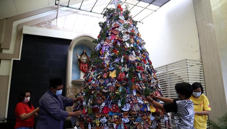 Pohon natal berhias masker di pintu masuk Gereja Kristus Raja