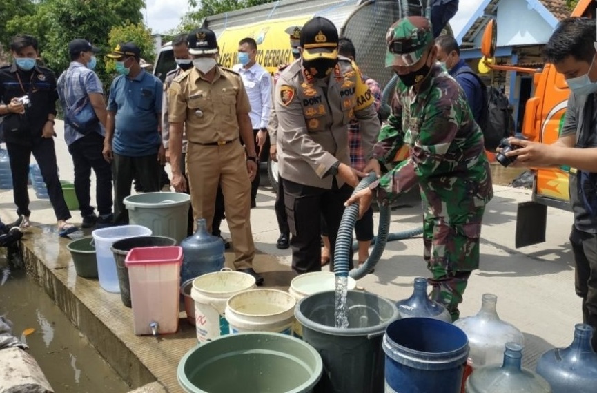 Kapolres Mojokerto AKBP Dony Alexander memberikan bantuan air bersih kepada warga terdampak banjir (Foto / Metro TV)