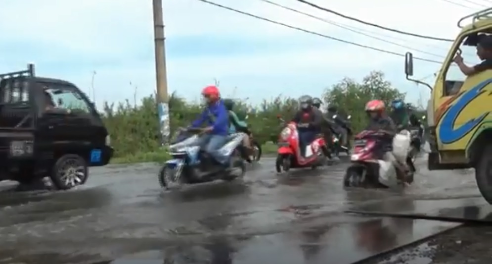 Jalan berlubang tertutup genangan air di kawasan Legundi-Bunder Kabupaten Gresik (metrotv)