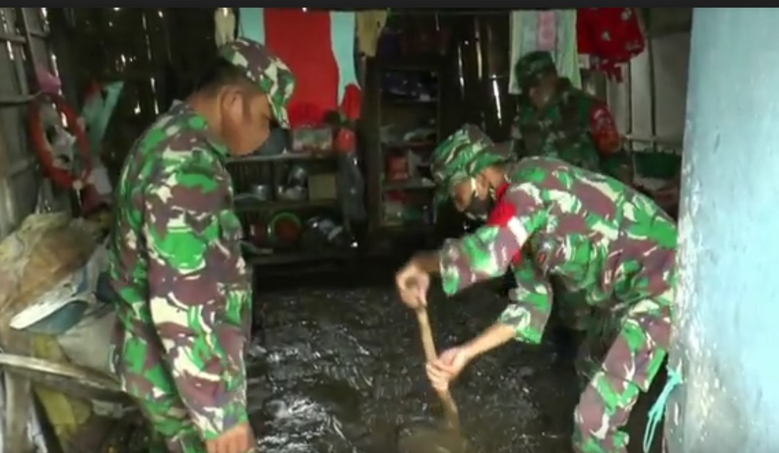 Prajurit TNI dan Polri membantu warga membersihkan lumpur akibar banjir bandang. (metrotv)