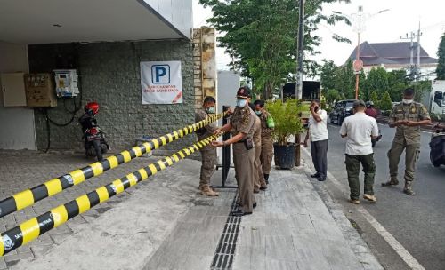 Anggota Satpol PP Mojokerto memasang garis penyegalan kantor BNI Mojokerto lantaran melanggar IMB (Foto / Metro TV)