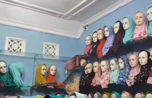 Ular piton berada di atas etalase toko jilbab. (metrotv)