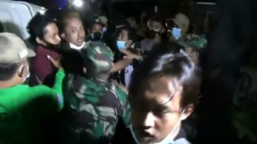 Petugas mencoba menahan emosi salah seorang pedagang saat ia tak tarima warungnya dirazia (Foto / Metro TV)